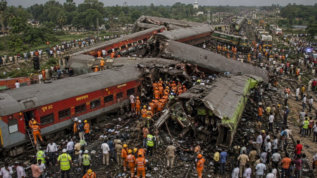 2023 की बालासोर रेल दुर्घटना (ओडिशा) का यथार्थवादी चित्र, जिसमें कोरोमंडल एक्सप्रेस, मालगाड़ी और यशवंतपुर–हावड़ा एक्सप्रेस की भीषण टक्कर के बाद क्षतिग्रस्त डिब्बे, राहत एवं बचाव अभियान और दुर्घटनास्थल का दृश्य दिखाया गया है।